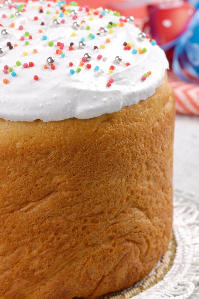 Пасхальный кулич с белой глазурью на столе 