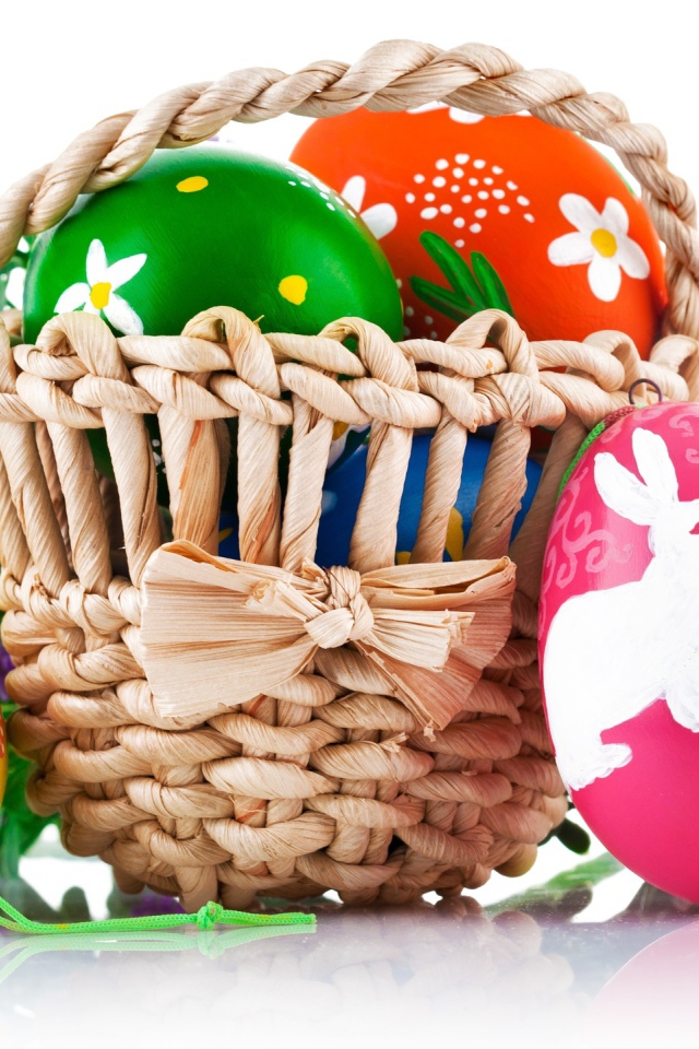 Пасхальные яйца с рисунком в корзине,  на белом фоне 