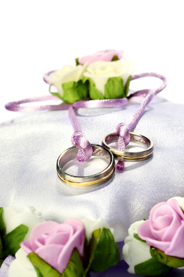 Два золотых обручальных кольца на подушечке на свадьбу