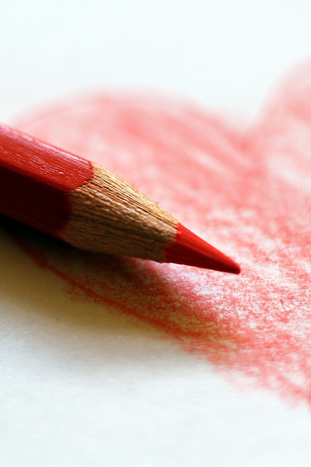 Нарисованное карандашом красное сердце на бумаге