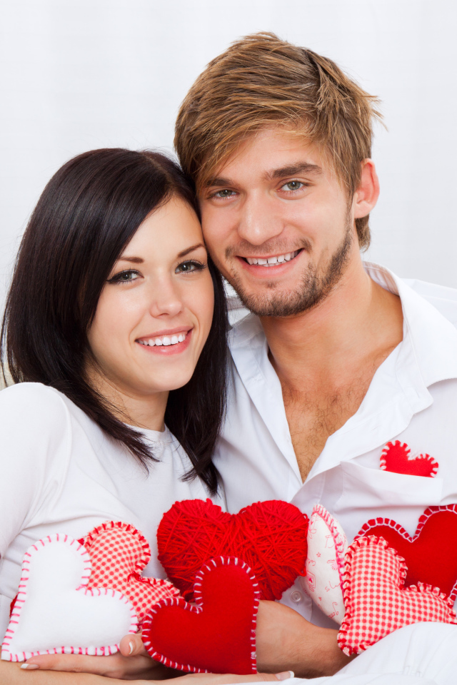 Красивая влюбленная пара с маленькими сердечками в руках