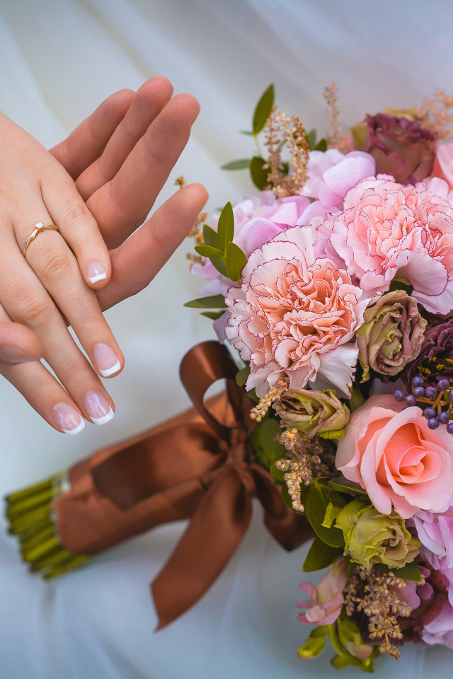 Руки влюбленной пары со свадебный букетов