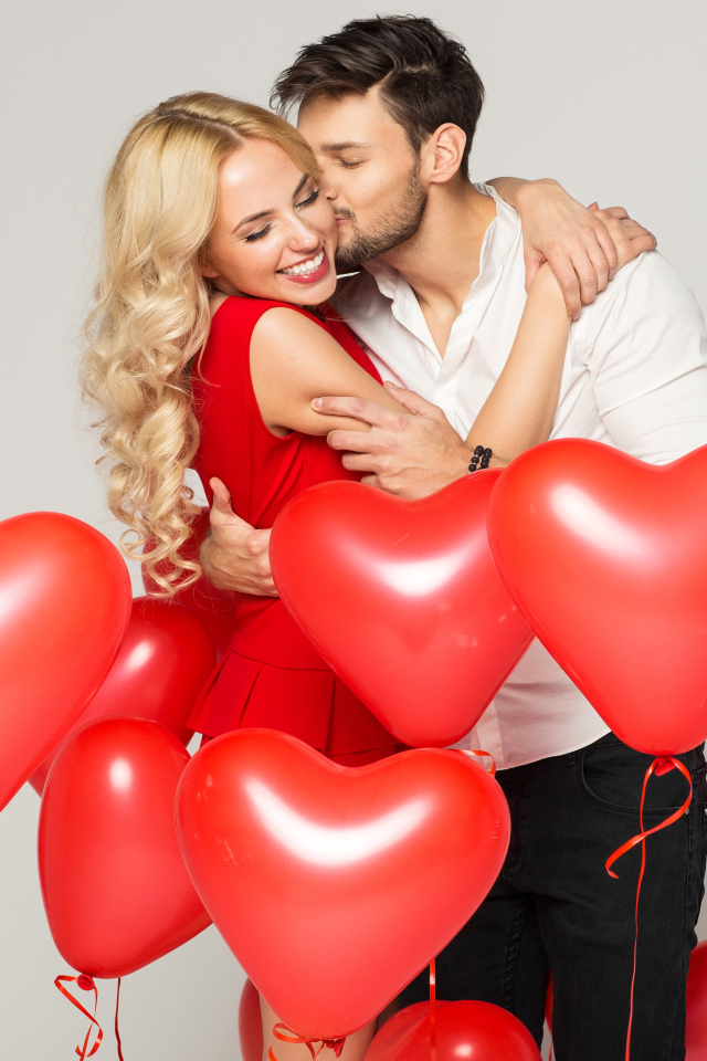 Счастливая влюбленная пара с воздушными шариками в форме сердца