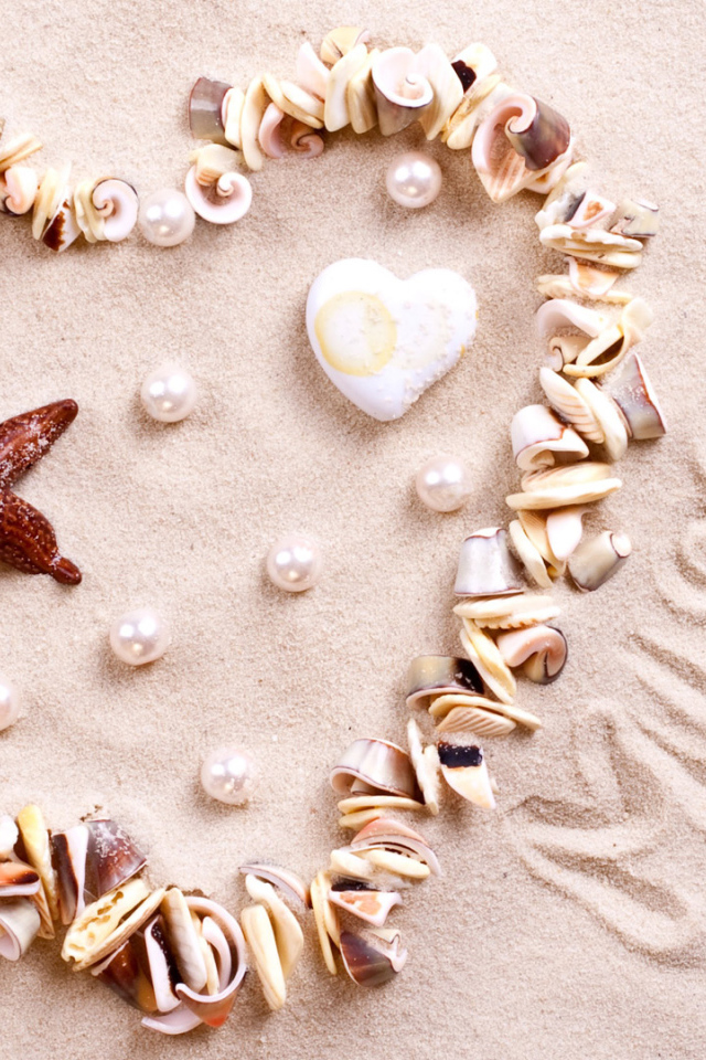 Сердце из ракушек на песке  