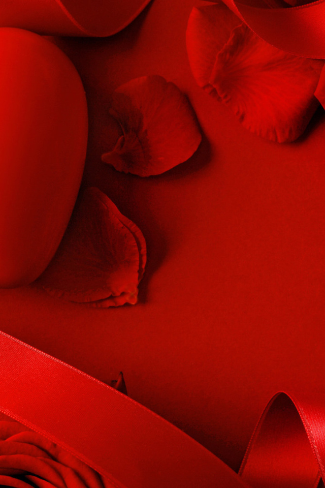 Красное сердце в лепестках красной розы  