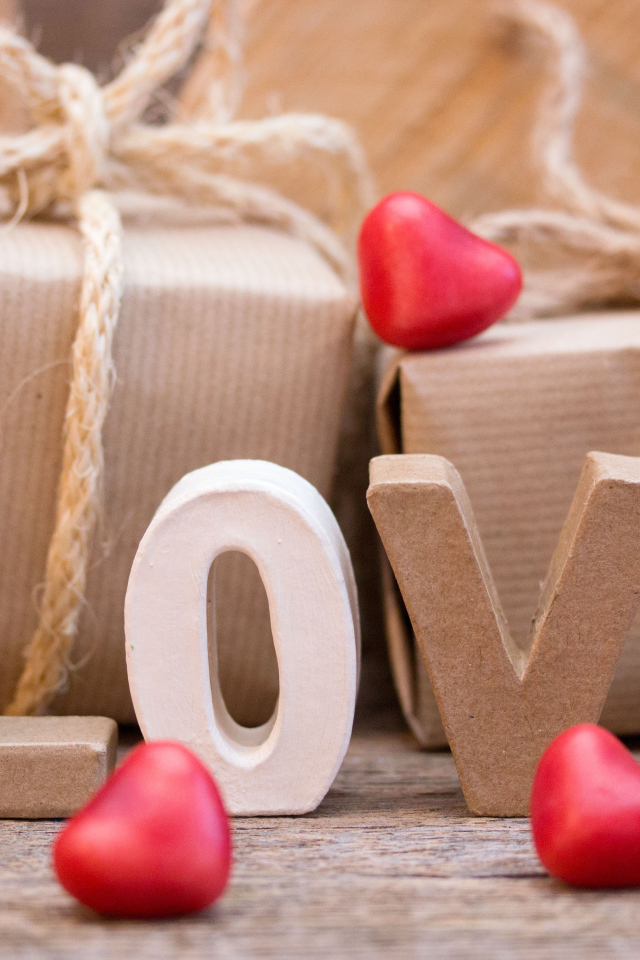 Романтические подарки и надпись Love с красными сердечками