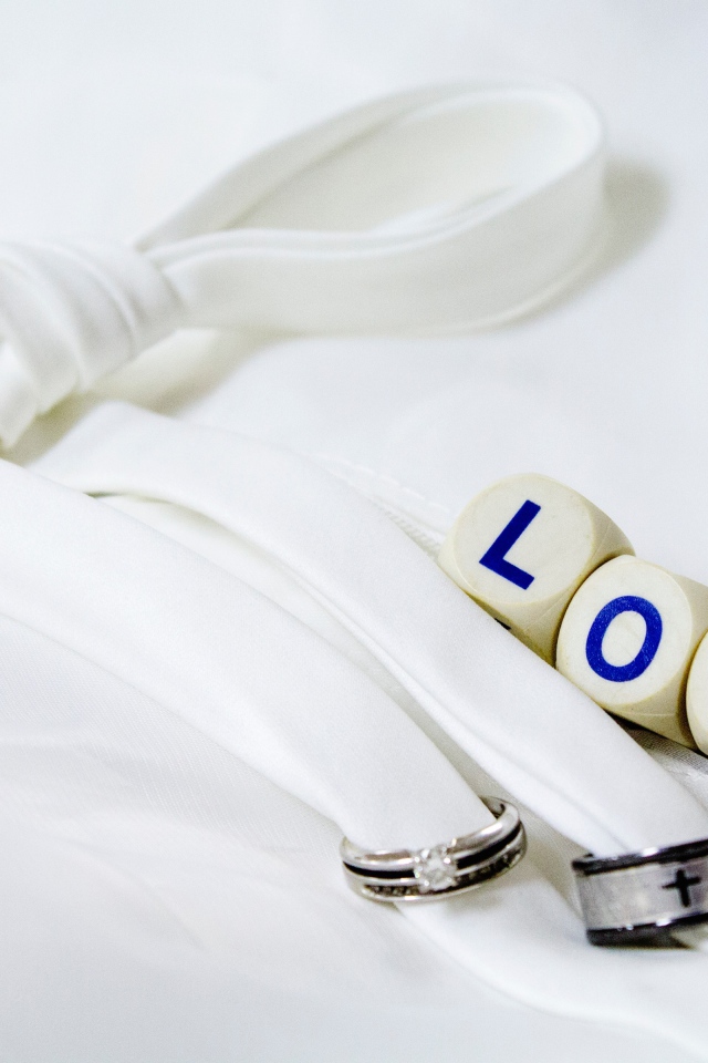 Два кольца перевязанные белой лентой и кубики с надписью любовь