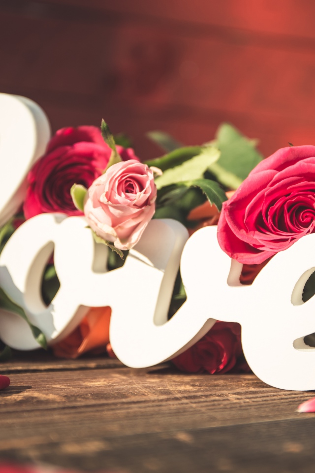 Белая надпись любовь с букетом роз