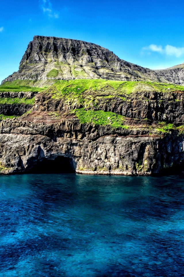 Маленький водопад стекает со скалы в океан, Гавайские острова