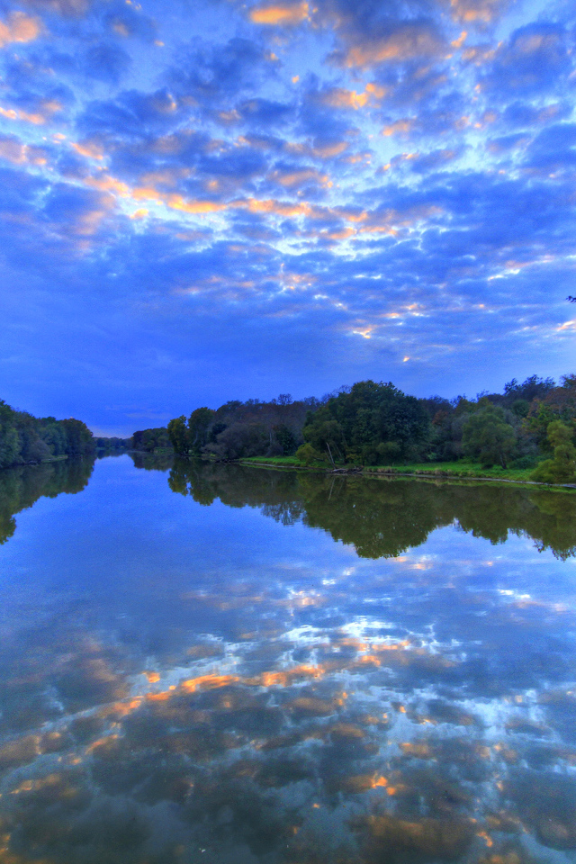 Красивое необычное небо отражается в реке