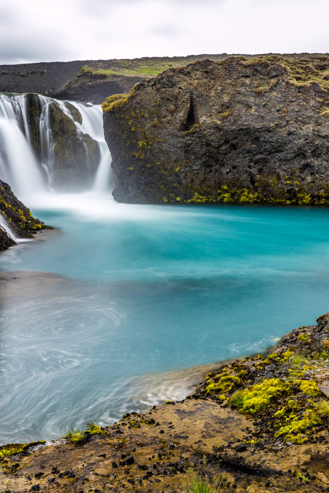 Красивый водопад между скалистых берегов 