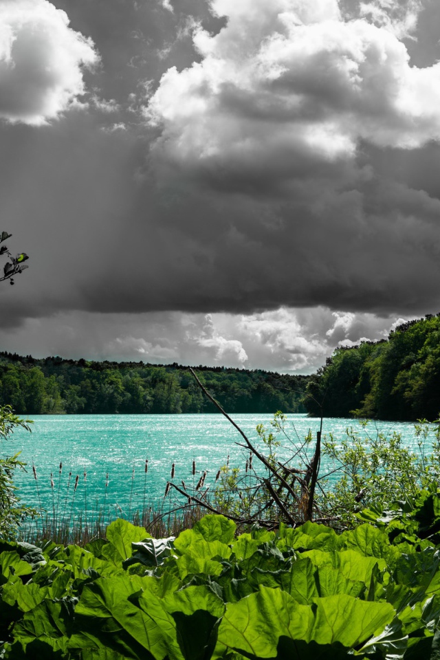 Голубая вода в озере на фоне дождевых облаков 