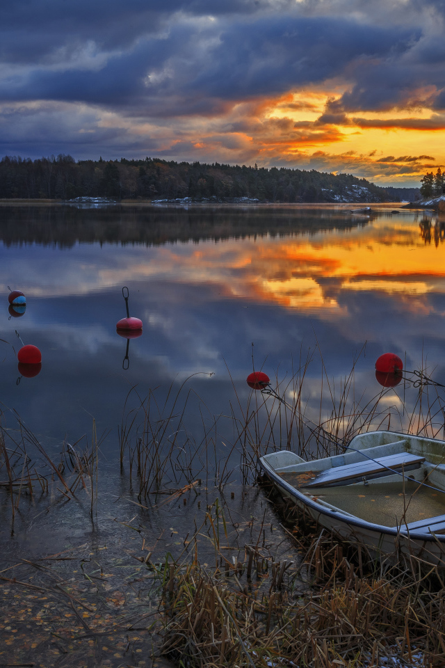 Лодки в тихом лесном озере на закате солнца
