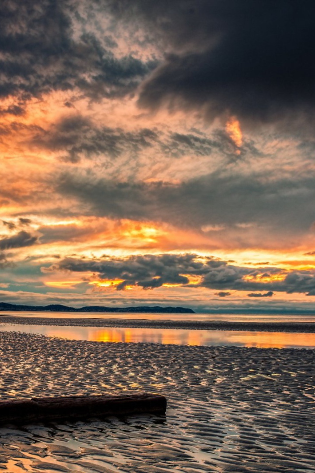 Прохладный закат в хмуром небе  над пляжем