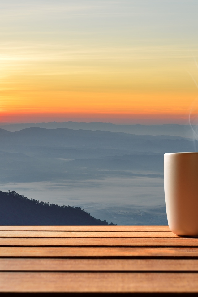 Чашка фоне на фоне горизонта с восходящим солнцем