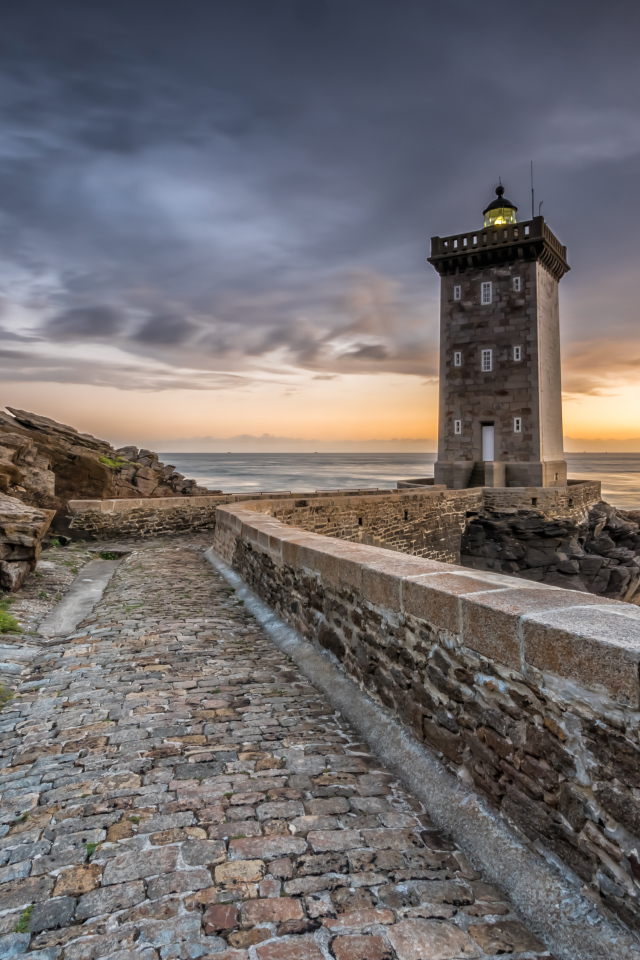 Маяк на берегу океана под красивым небом