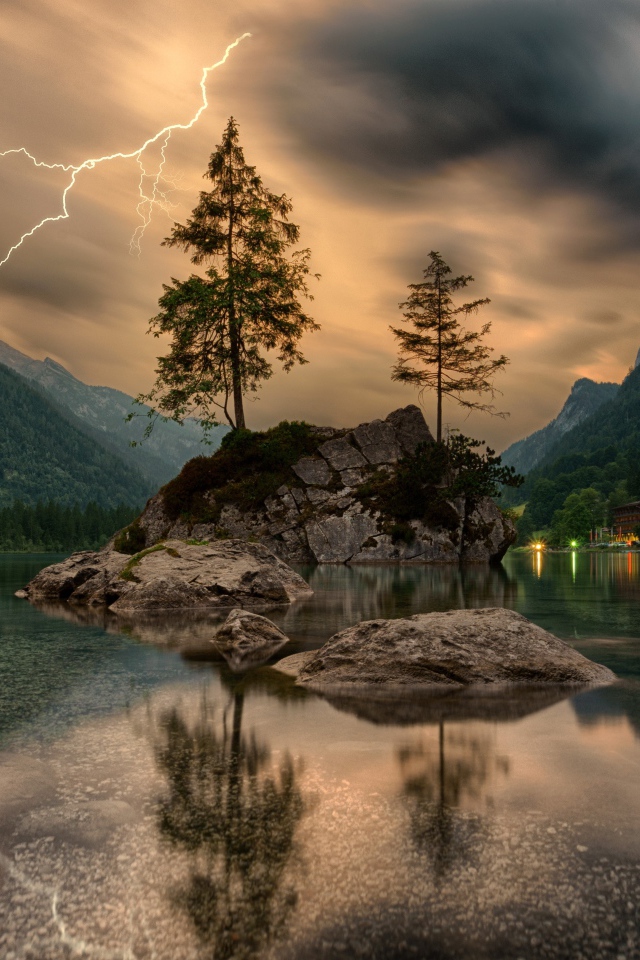 Молния в грозовых облаках над горным озером