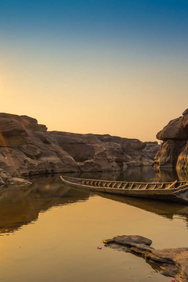 Лодна на озере между скал на рассвете