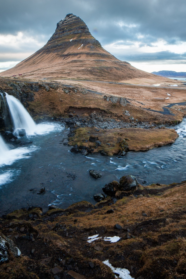 Гора и водопад у реки в Исландии  