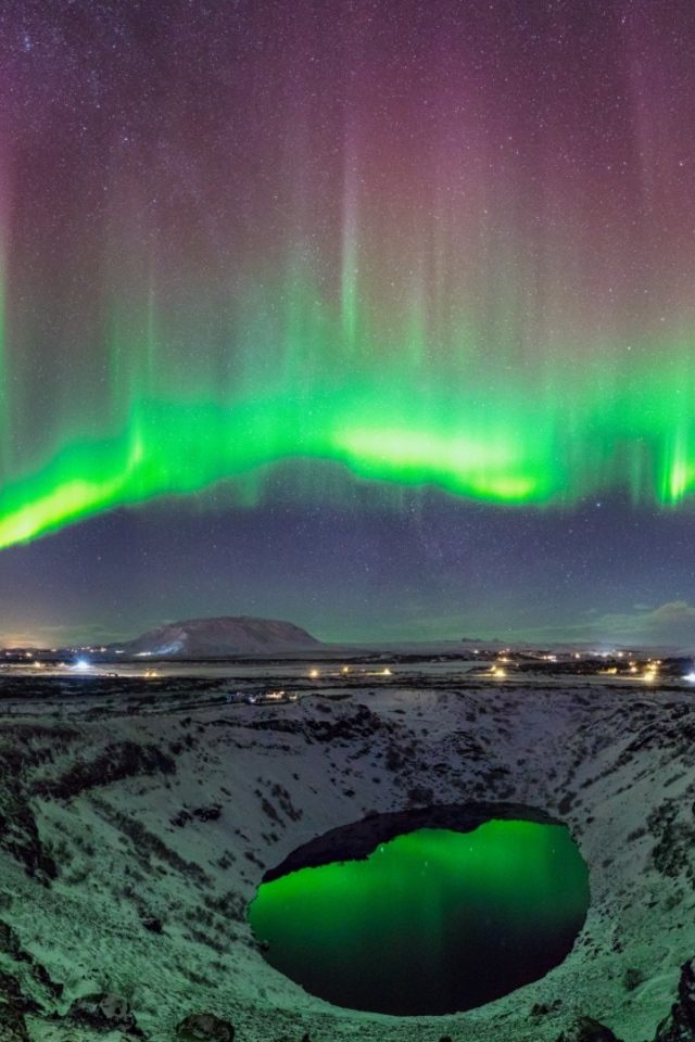 Северное сияние над заснеженным кратером вулкана 