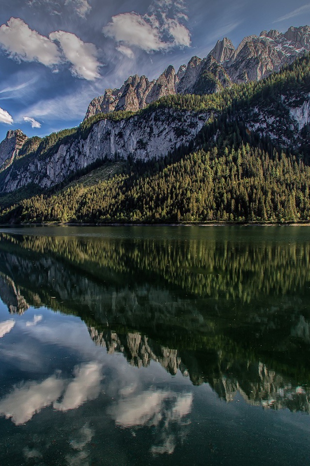 Сосны и горы отражаются в озере  