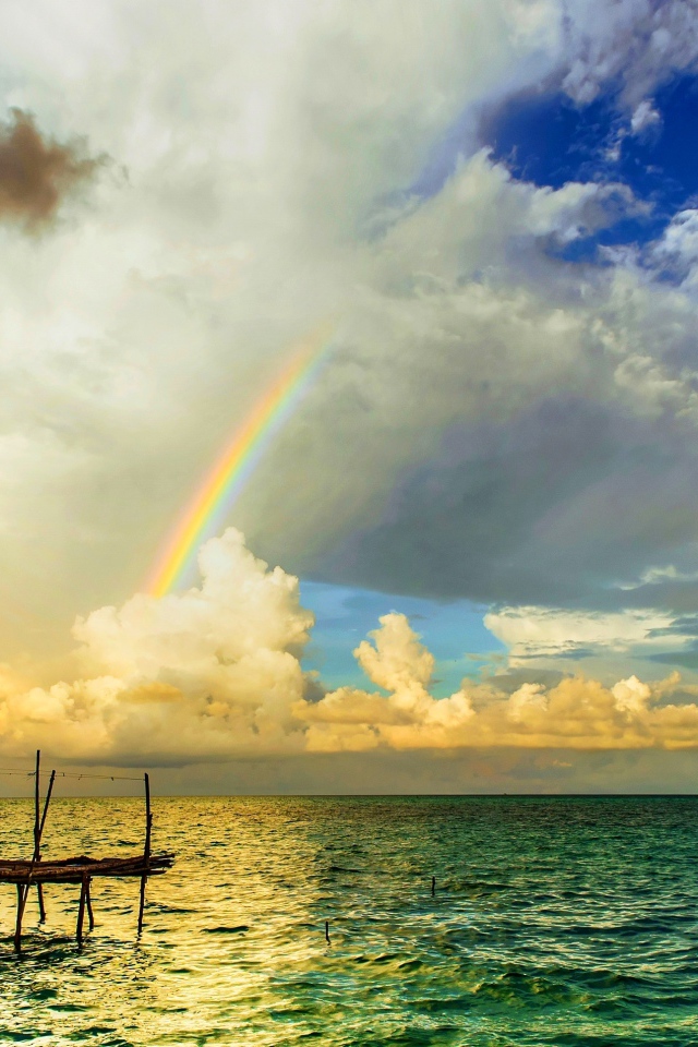 Радуга  над бунгало на тропическим пляжем 