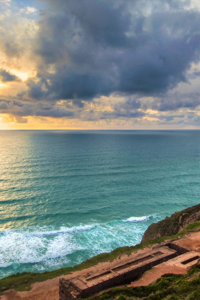 Руины здания на берегу океана под красивым  небом