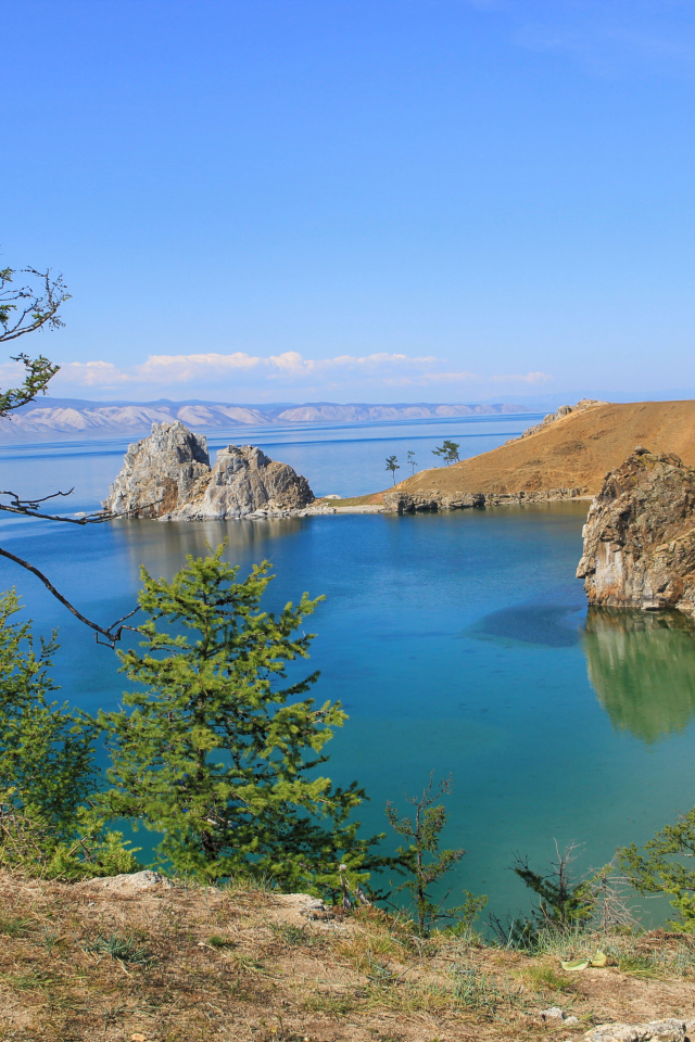 Каменные утесы у чистой воды живописного озера Байкал,  Россия