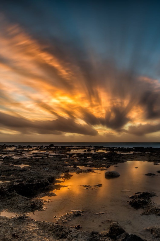 Закат солнца в облаках над водой 