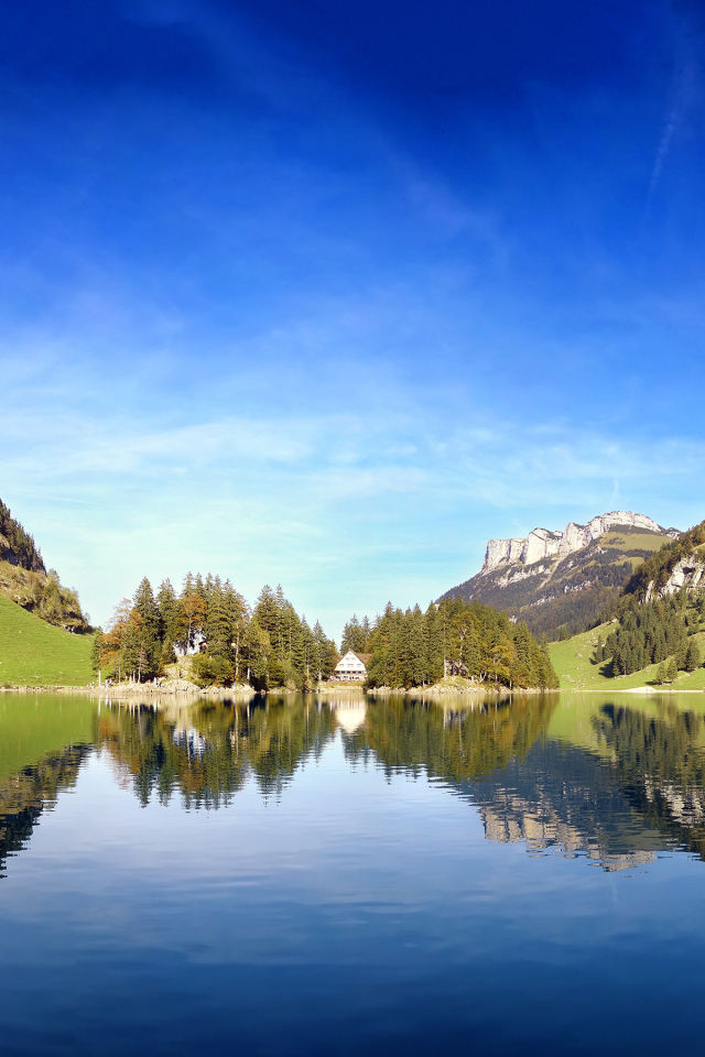 Горы отражаются в воде озера под красивым голубым небом, Швейцария