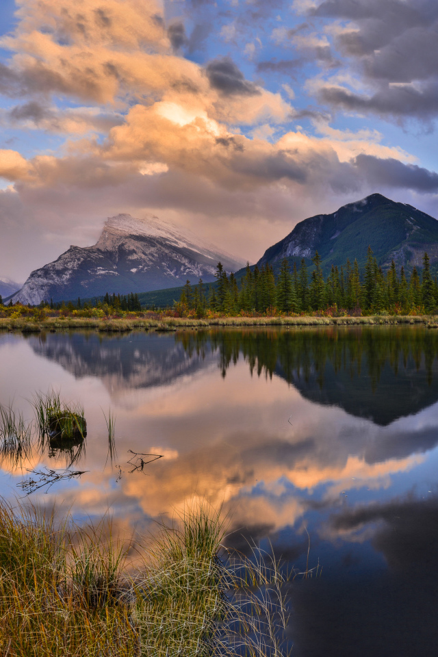 Небо и горы отражаются в чистой воде озера 