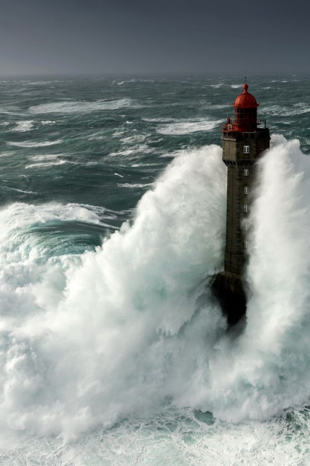 Бушующие волны окутывают маяк 
