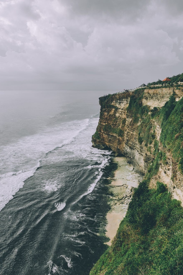 Бушующие волны у зеленого утеса 