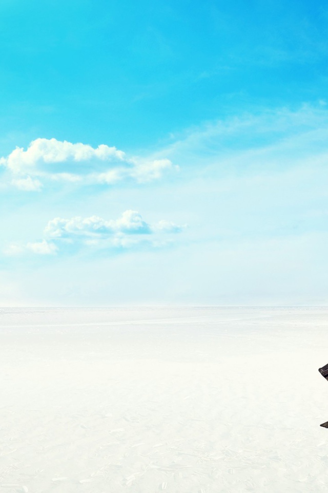 Шезлонг на белом песке на фоне голубого неба