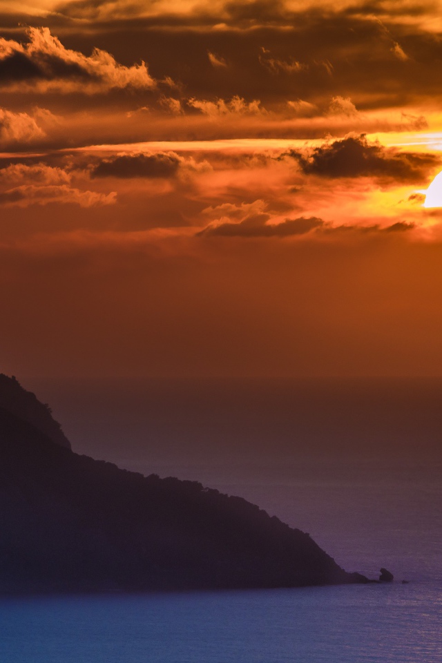 Туманный закат солнца над океанской гладью 