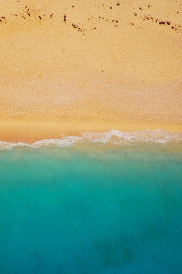 Желтый песок соединяется с голубой водой 