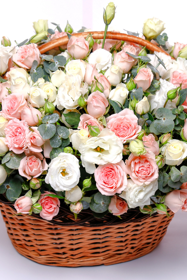 Корзина с красивым букетом цветов роз, эустомы на розовом фоне