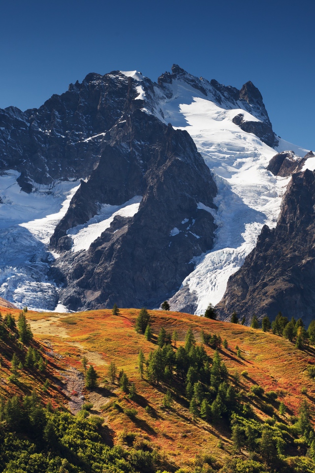 Заснеженные горы на фоне голубого неба 