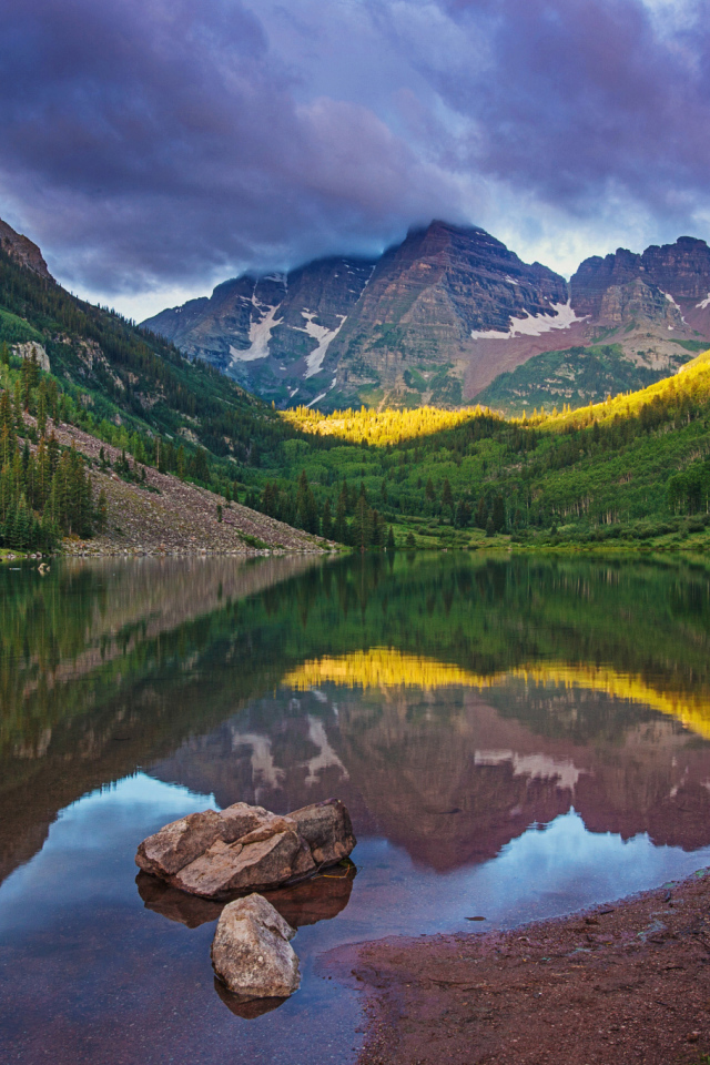 Покрытые зеленью горы отражаются в чистой воде озера