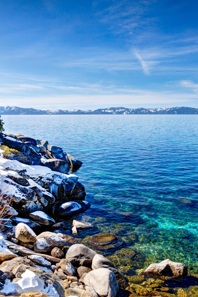 Чистая вода в озере Тахо с покрытыми снегом берегами, США