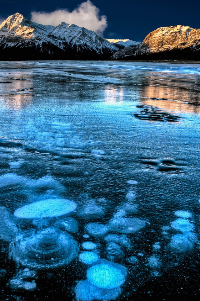 Покрытое льдом чистое  озеро Эйбрахам на фоне гор, Канада