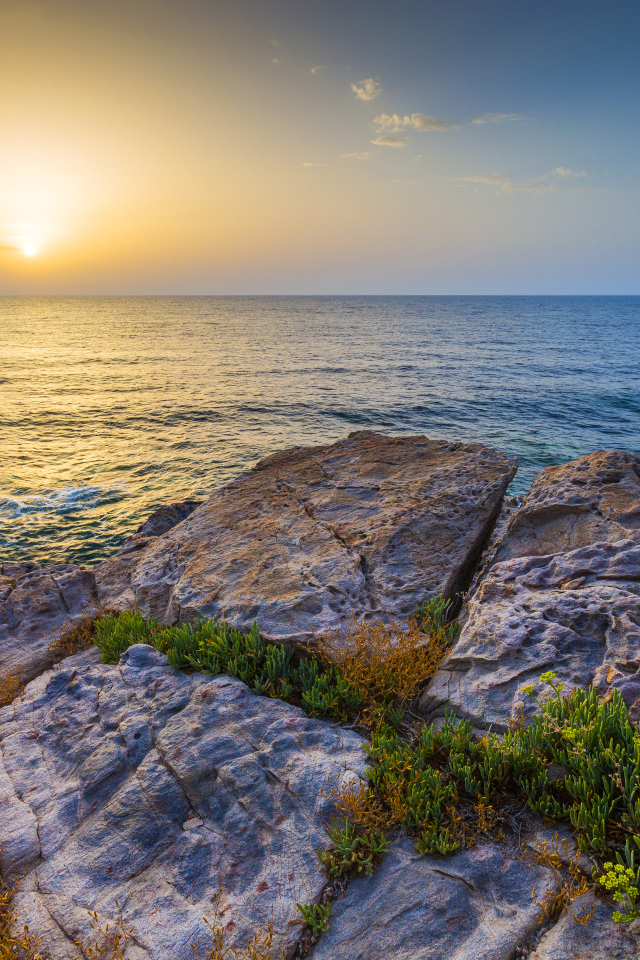 Каменные скалы на закате солнца над Средиземным морем, Греция