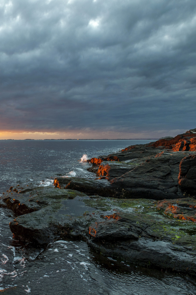 Каменное побережье в Норвегии на закате 