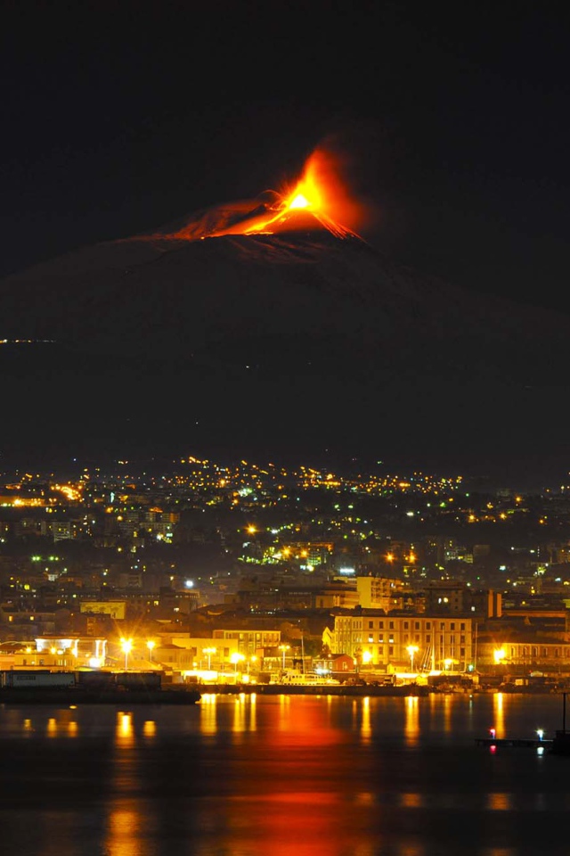 Пробуждение вулкана Этна на фоне ночного города 