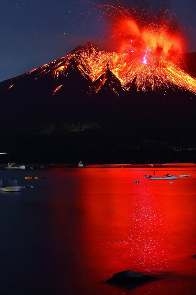 Вулкан Сакурадзима извергается  на фоне воды 