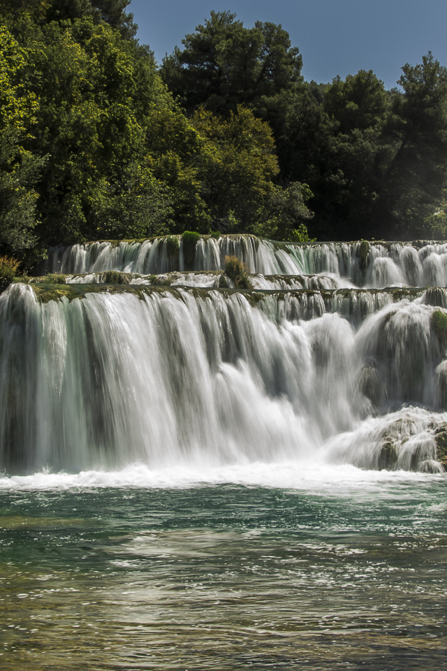 Быстрый водопад впадает в реку 