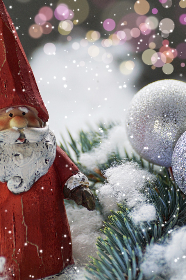 Figurine of Santa Claus near the spruce branch and bright balls