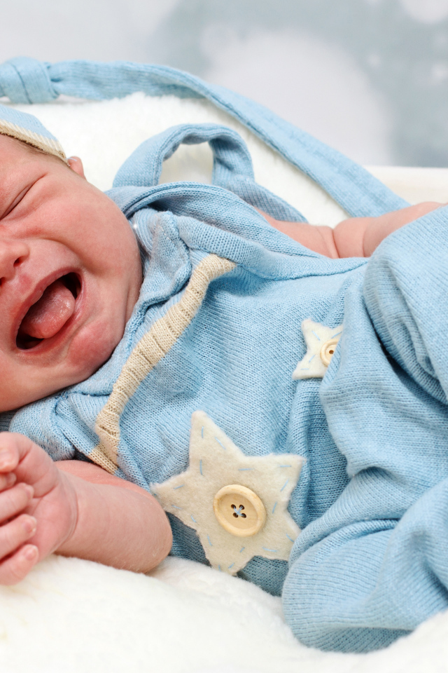 Плачущий младенец в голубом костюме