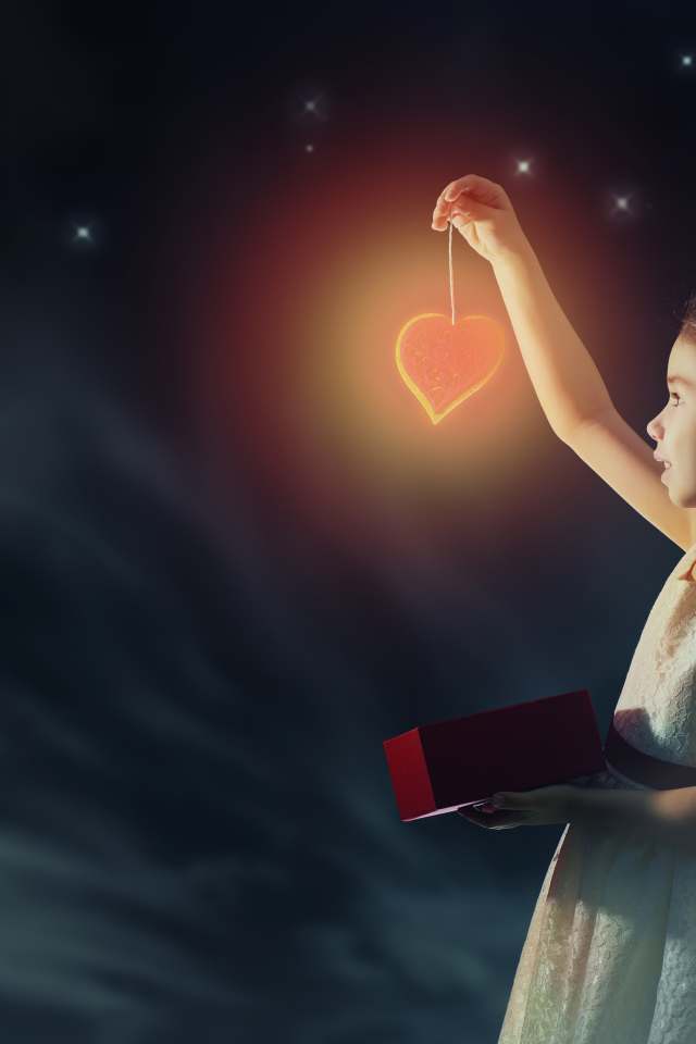 Девочка в красивом белом платье держит в руках сердечко