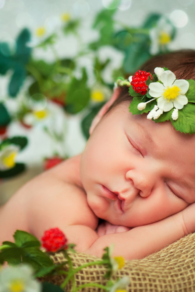 Спящий грудной ребенок с красивой повязкой на голове